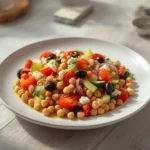 Greek Chickpea Salad: Fresh Greek chickpea salad with chickpeas, tomatoes, cucumber, olives, and feta in a bowl.