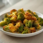 Keto Broccoli Fries: Crispy golden keto broccoli fries on a baking sheet with parmesan coating