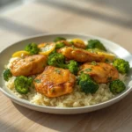 Lemon Garlic Chicken Bowl: Juicy lemon garlic chicken bowl with golden chicken, rice, and broccoli in a skillet.