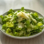 Lemon Parmesan Lettuce: Crisp romaine lettuce with shaved parmesan and lemon dressing in a bowl, Mediterranean Diet Salads.