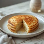 Almond Flour Pancakes: Fluffy golden almond flour pancakes stacked high on a plate with berries, perfect for keto breakfast recipes.