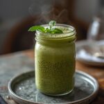 Avocado Spinach Protein Shake: Creamy green avocado spinach protein shake in a tall glass with a light frothy top and chia seeds visible.