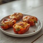 Bacon Wrapped Jalapeño Poppers: Golden crispy bacon wrapped jalapeño poppers on a baking sheet with creamy melted filling.