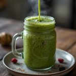 Belly Fat Burner Smoothie: Creamy green belly fat burner smoothie in a glass with berries and chia seeds on top.