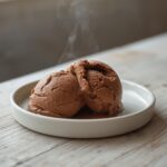 Chocolate Avocado Ice Cream: Creamy chocolate avocado ice cream in a bowl with a smooth, rich texture and deep brown color.