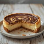 Chocolate Swirl Keto Cheesecake: Creamy Chocolate Swirl Keto Cheesecake with a glistening chocolate pattern on a white plate.