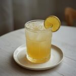 Coconut Water Pineapple Refresher: Glistening golden tropical drink with pineapple chunks and ice in a clear glass, perfect for hydration.