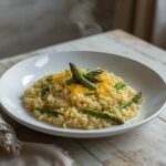 Creamy Asparagus Risotto: Creamy asparagus risotto in a white bowl with glistening parmesan and tender green asparagus pieces.