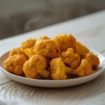 Crispy Cauliflower Bites: Golden crispy cauliflower bites in an air fryer basket, ready to eat.