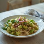 Keto Avocado Chicken Salad: Keto Avocado Chicken Salad in a white bowl with creamy avocado, fresh cilantro, and shredded chicken.