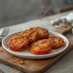 Keto Fried Green Tomatoes: Crispy golden keto fried green tomatoes with a crunchy coating and glistening edges on a wooden board.
