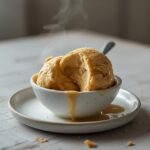 Keto Ice Cream: Creamy keto ice cream scooped in a bowl with a smooth, glistening texture and sweet vanilla aroma.