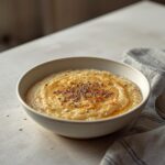Keto No Oat Oatmeal: Creamy keto no oat oatmeal in a rustic bowl with a golden, comforting texture and a sprinkle of cinnamon.