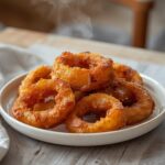 Keto Onion Rings: Golden crispy keto onion rings on a plate with a light glaze and crisp edges.
