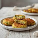 Keto Zucchini Fritters: Crispy golden keto zucchini fritters with crisp edges on a white plate, low carb snack.