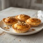 Lebanese Meat Pies: Golden flaky Lebanese meat pies with spiced ground beef filling on a baking sheet.