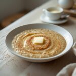 Low Carb Flax Porridge: Creamy low carb flax porridge in a bowl with a golden, glistening texture and a butter pat on top.
