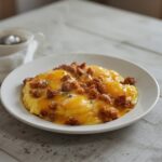 Low Carb Sausage Scramble: A skillet of low carb sausage scramble with golden scrambled eggs and melted cheese.