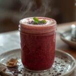 Mixed Berry Keto Smoothie: A glass of creamy, ruby-red mixed berry keto smoothie on a wooden table with fresh berries nearby.