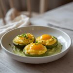 Scrambled Egg Avocado Bowl: Creamy golden scrambled eggs on sliced avocado in a white bowl with chives, keto breakfast idea