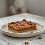 Pecan Crust Keto Bars: Golden pecan crust keto bars on a plate, toasted and caramelized with a firm texture.