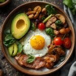 A colorful and healthy keto breakfast with egg, avocado, vegetables, and ham on a plate